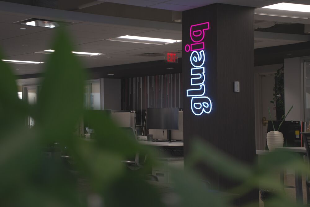 The glueiq neon sign glowing on a dark column after hours