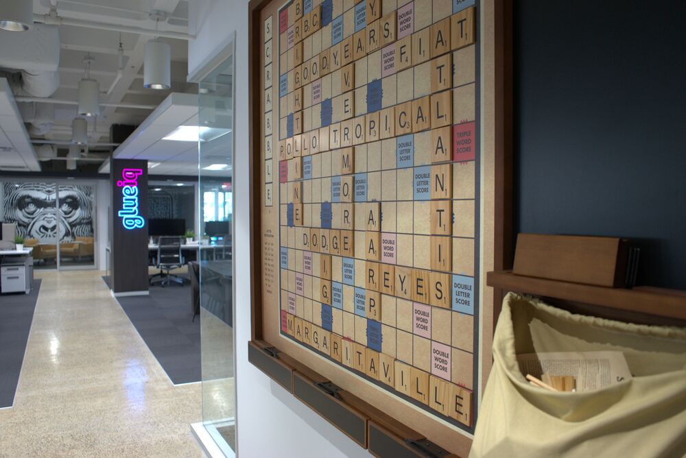 A giant wall-mounted Scrabble board spelling out client names